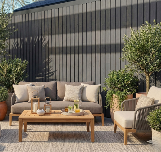 Luxe loungeset op modern terras met zwarte verticale composiet gevelbekleding en olijfbomen
