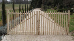 Dubbele houten tuinpoort van kastanjehout met gepunte latten voor een brede doorgang