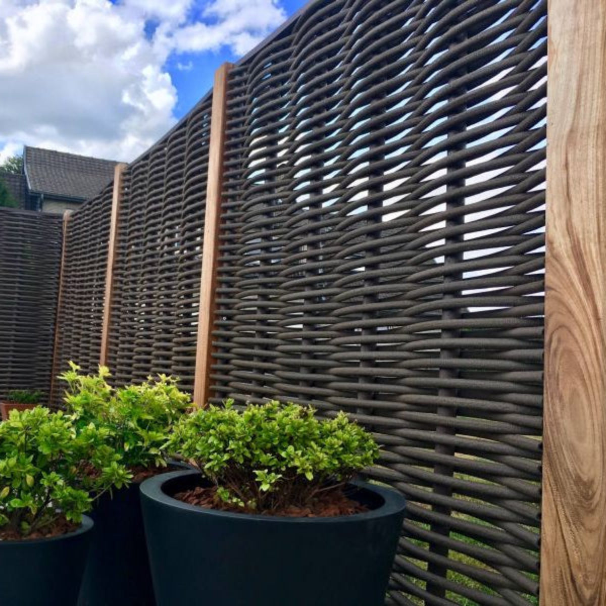 Forest Avenue fiber gevlochten tuinscherm in bruin met tropisch hardhouten palen