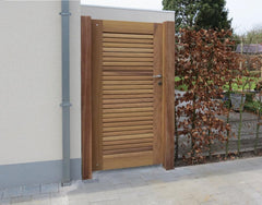 Moderne houten tuinpoort in Iroko met lamellenstructuur en hoogwaardig RVS deurbeslag, passend bij de lamellen opritpoort.